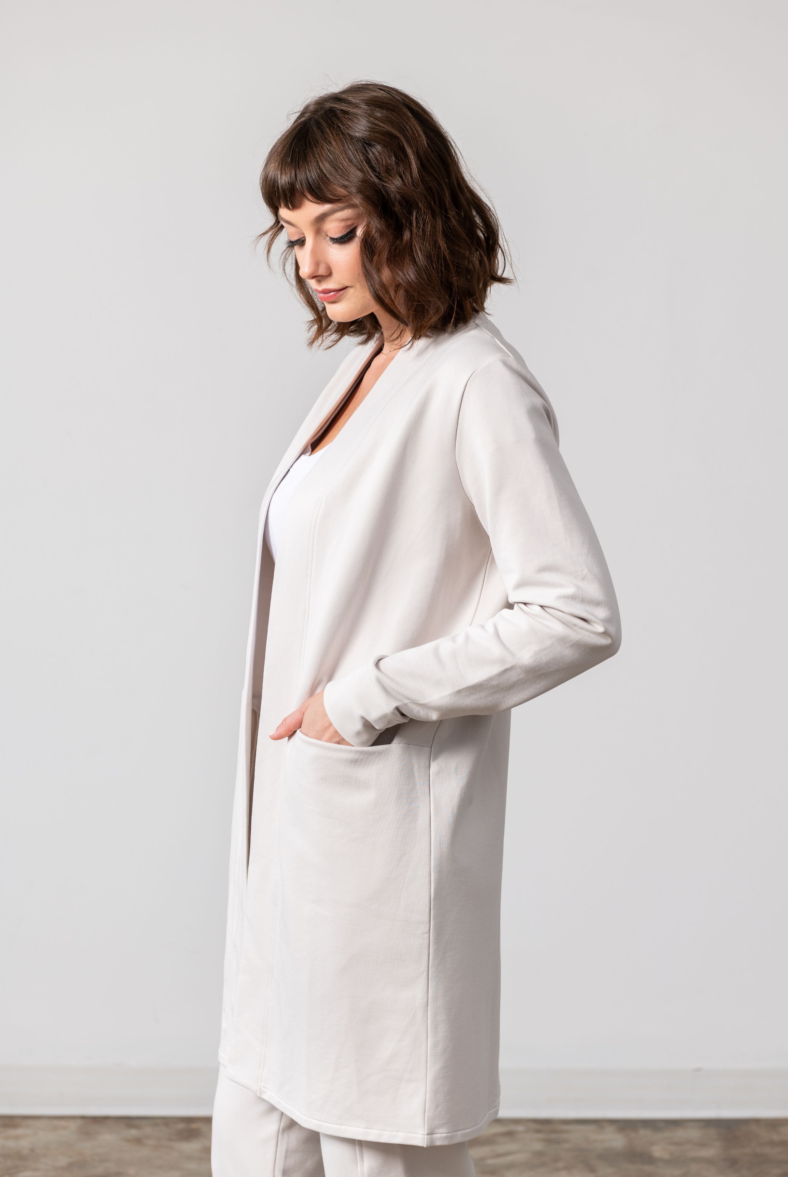 Woman shown wearing Light Beige cardigan with hand in her pocket